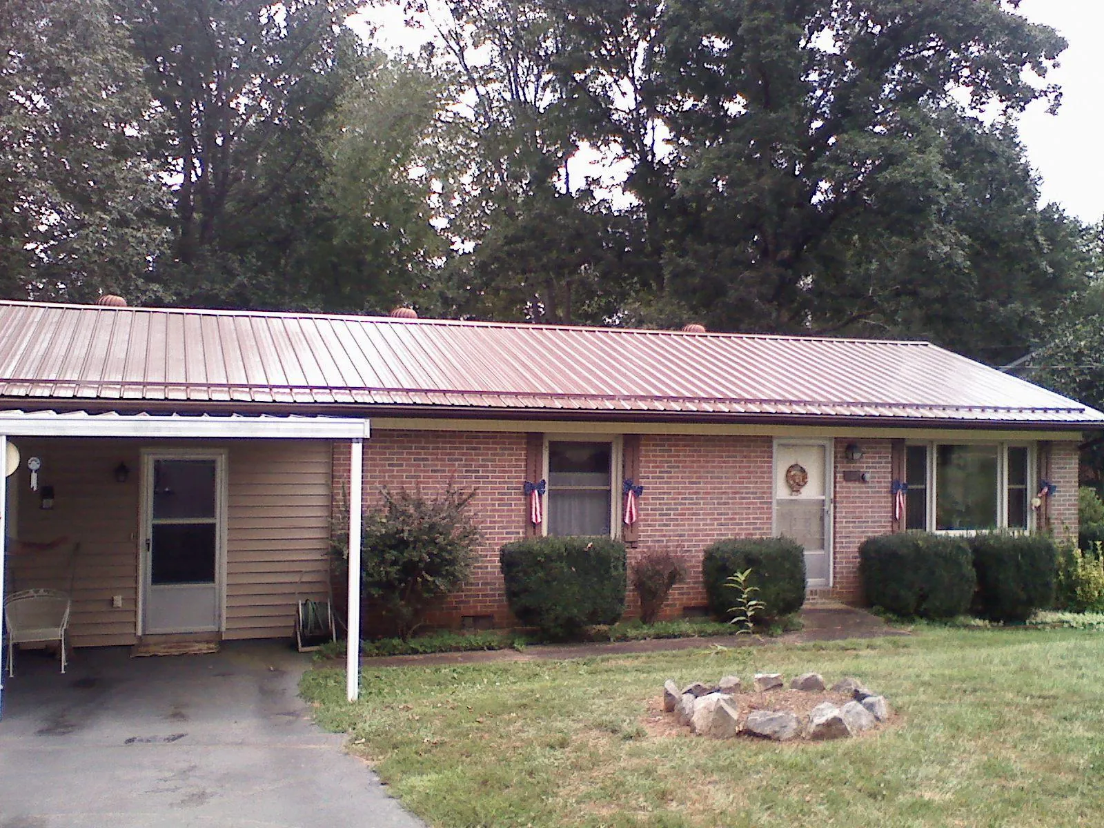 Bronze metal roof and carport on a brick ranch home — Roof Repair work by our crew in Layton
